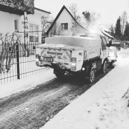 Winterdienst-Fahrzeug räumt eine verschneite Wohnstraße und sorgt für freie und sichere Zufahrten im Winter